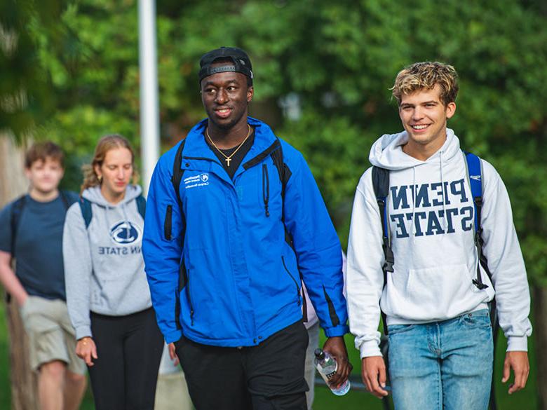 Students walking near the Penn State Altoona campus reflecting pond.