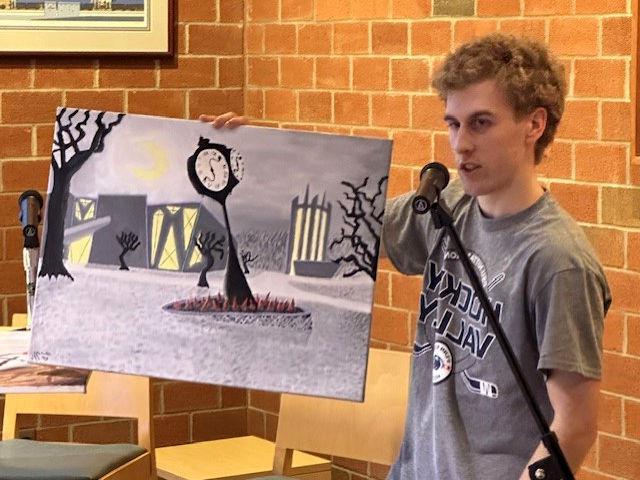 Student Talon McKendree displays an original painting of the Penn State Altoona campus in the style of German Expressionism.